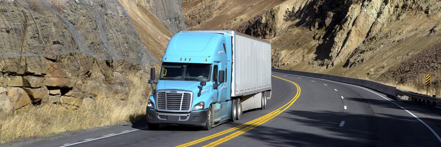 blue and white semi truck drives on freeway to deliver manufacturing parts Worldwide Sourcing & Solutions United States, China